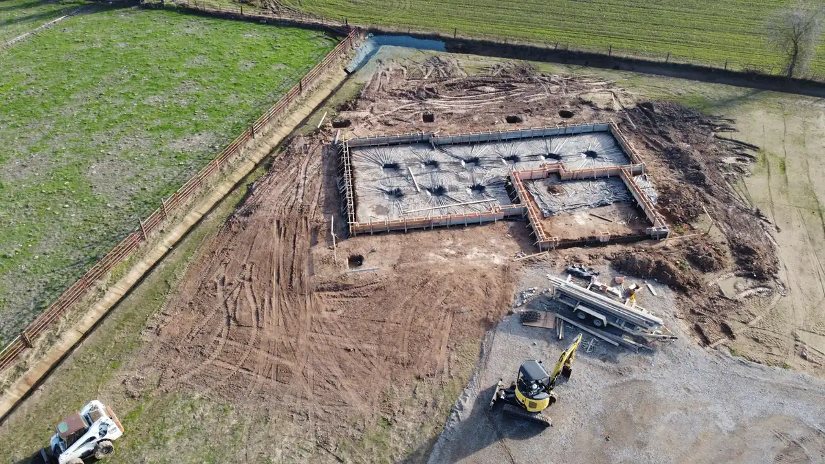 The foundation of a building from above, the concrete strips tracing the floor plan