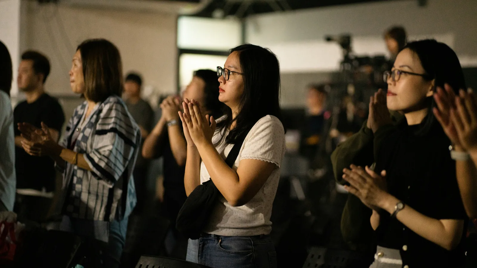 People applauding in a room, seen up close