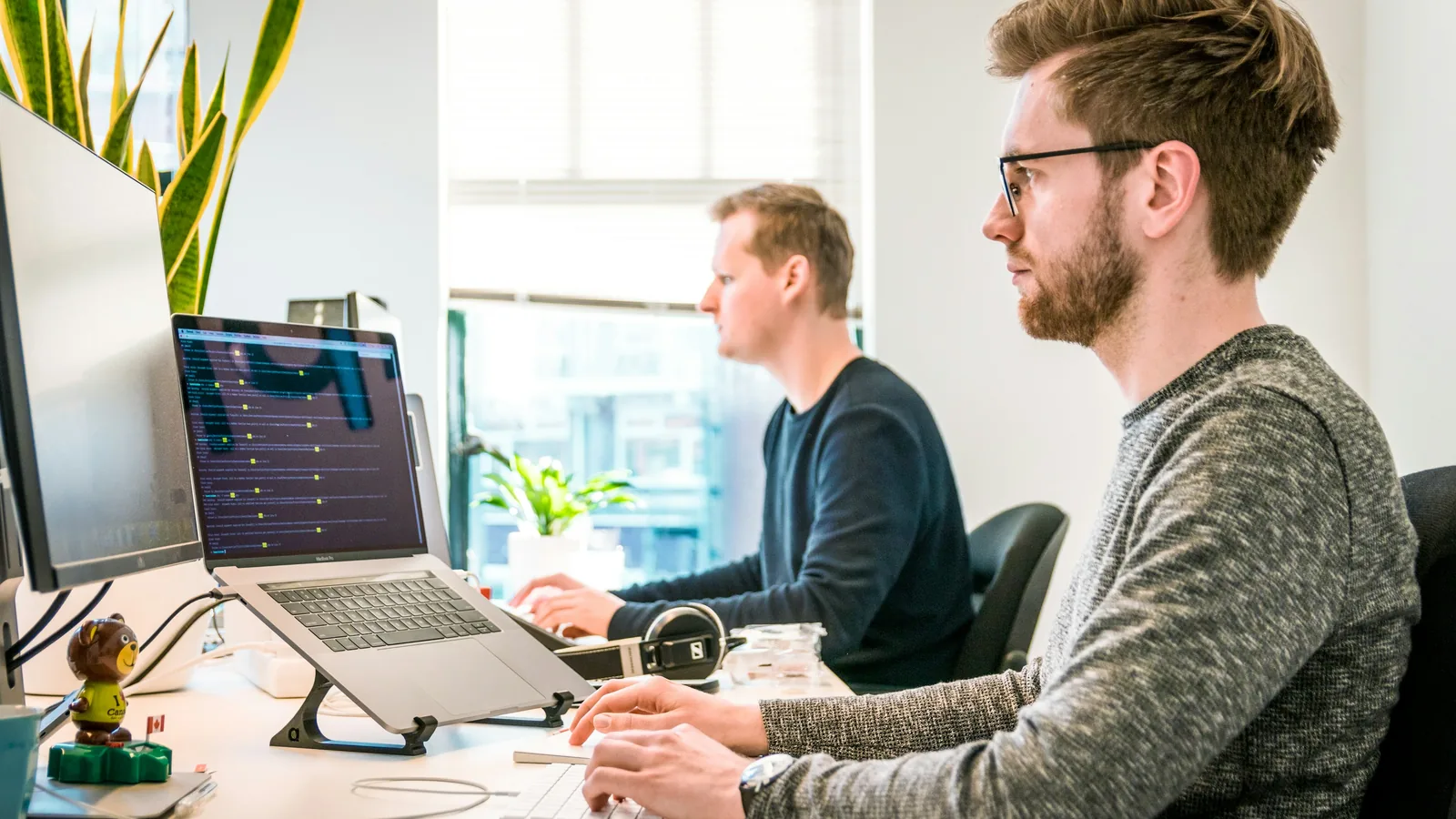 Two developers working side by side at their screens