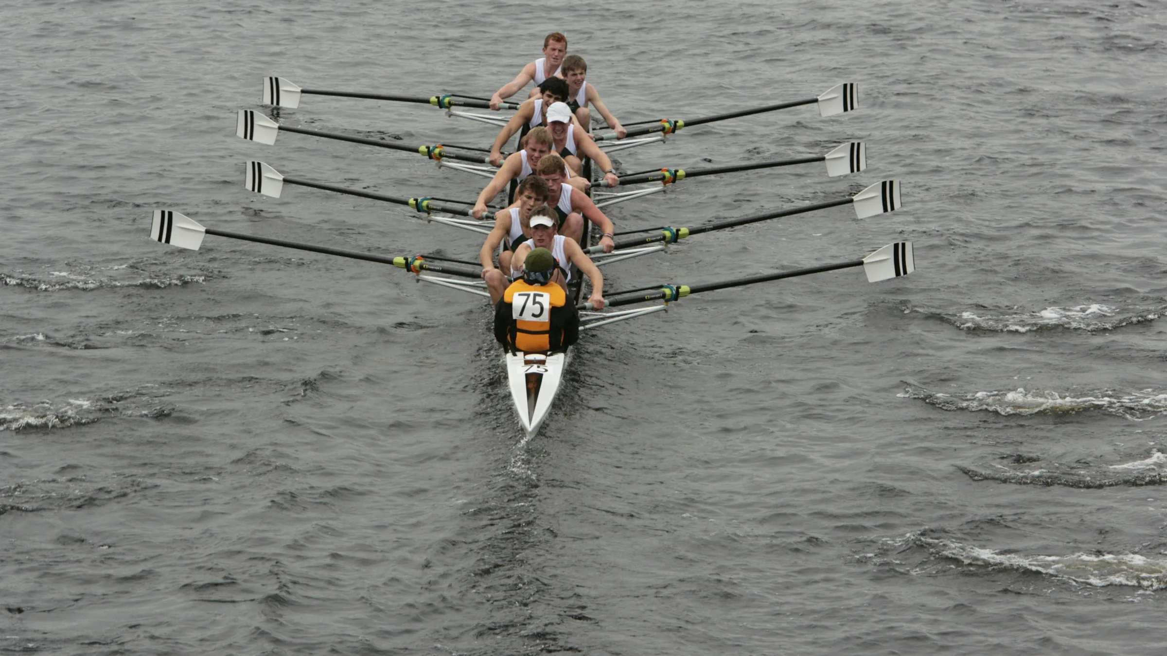 A rowing eight seen head on, the oars entering the water together