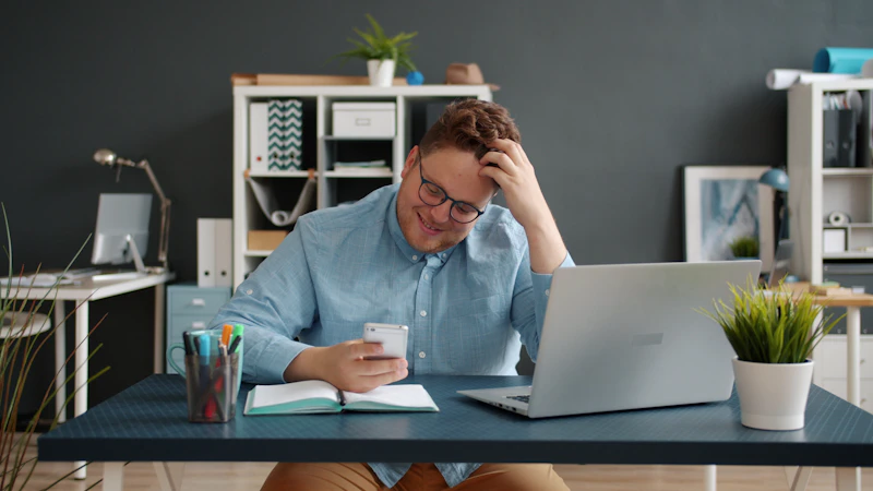 Man looking at phone with hand in hair