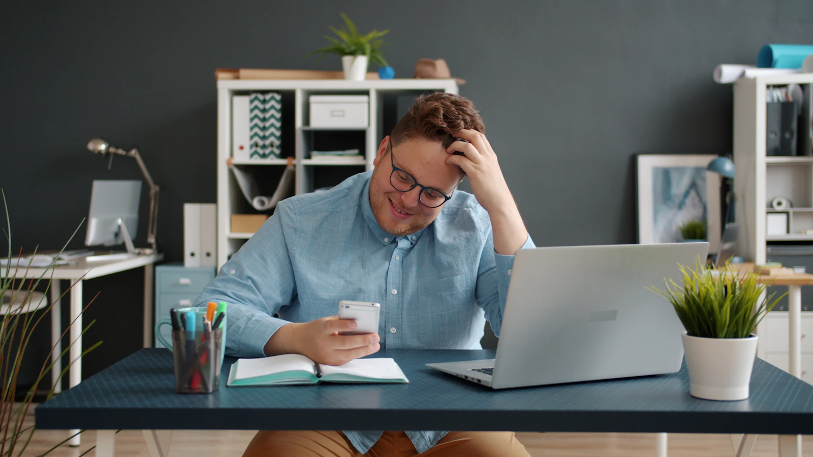 Man looking at phone with hand in hair
