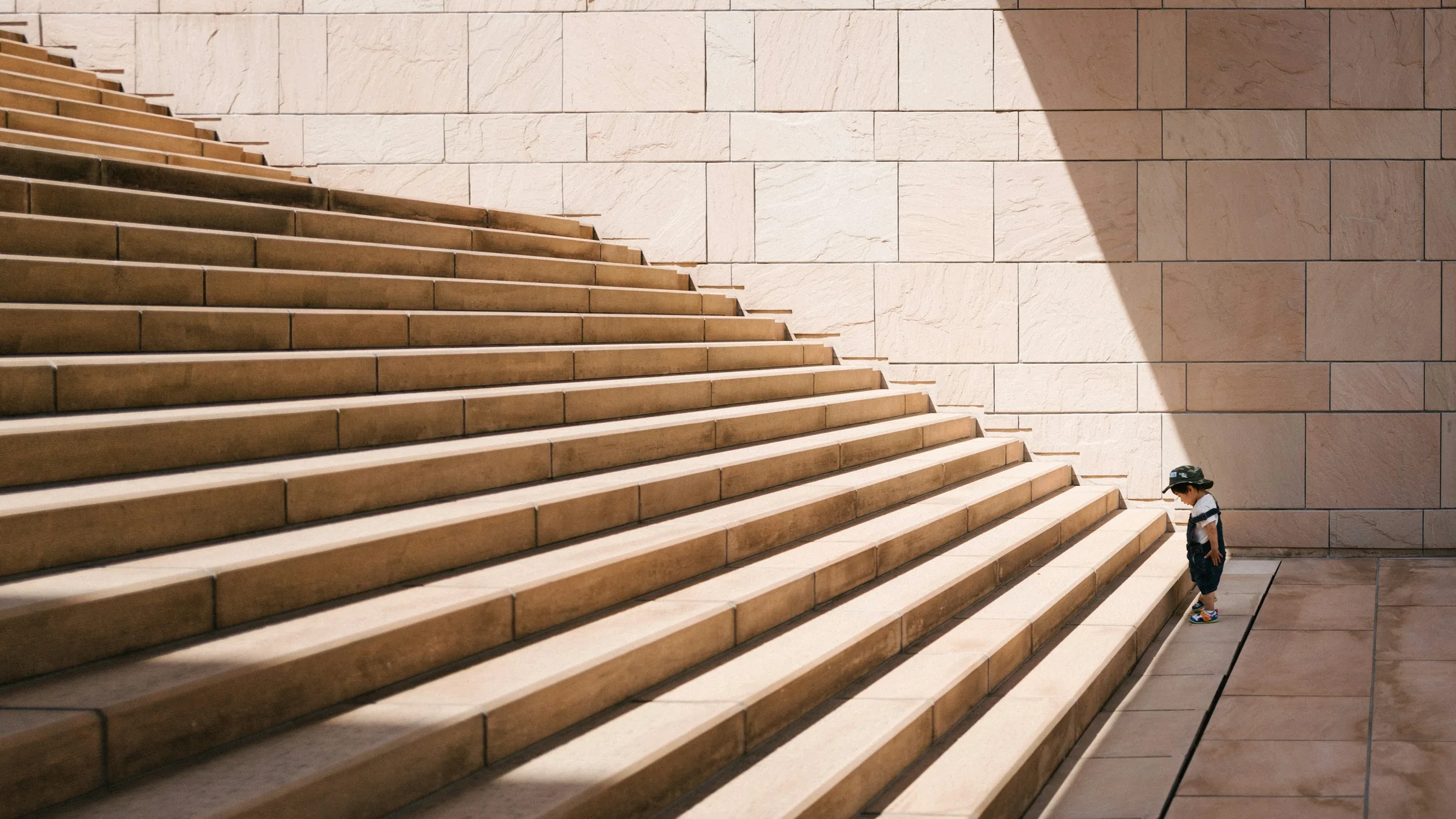 A wide stone staircase with a single figure starting the climb